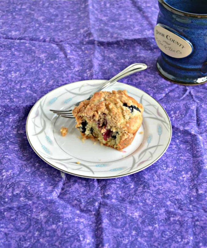 A berry muffin made with sourdough discard sitting on a plate with a fork.