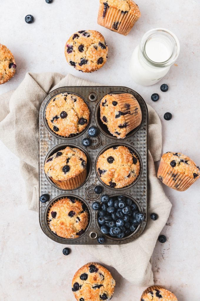 Aerial photo of sourdough blueberry muffins in a muffin tin.