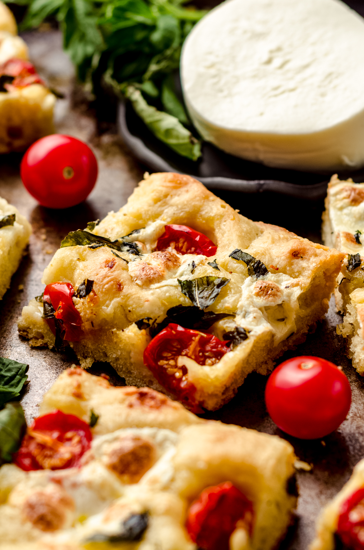 Caprese focaccia slice on a baking sheet.