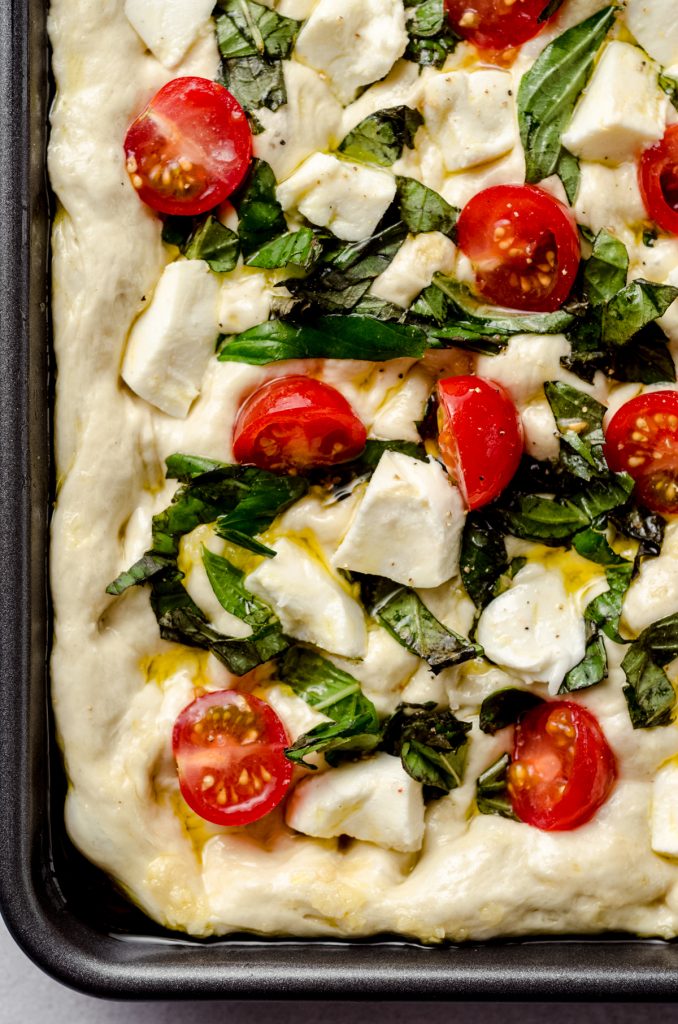 Caprese focaccia dough in a baking dish.