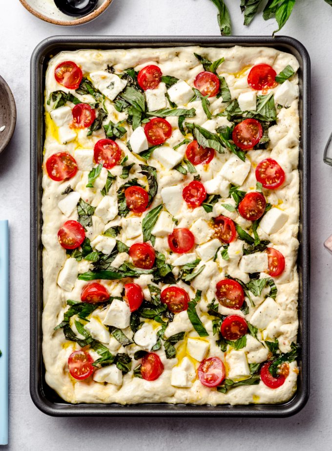 Caprese focaccia dough in a baking dish.