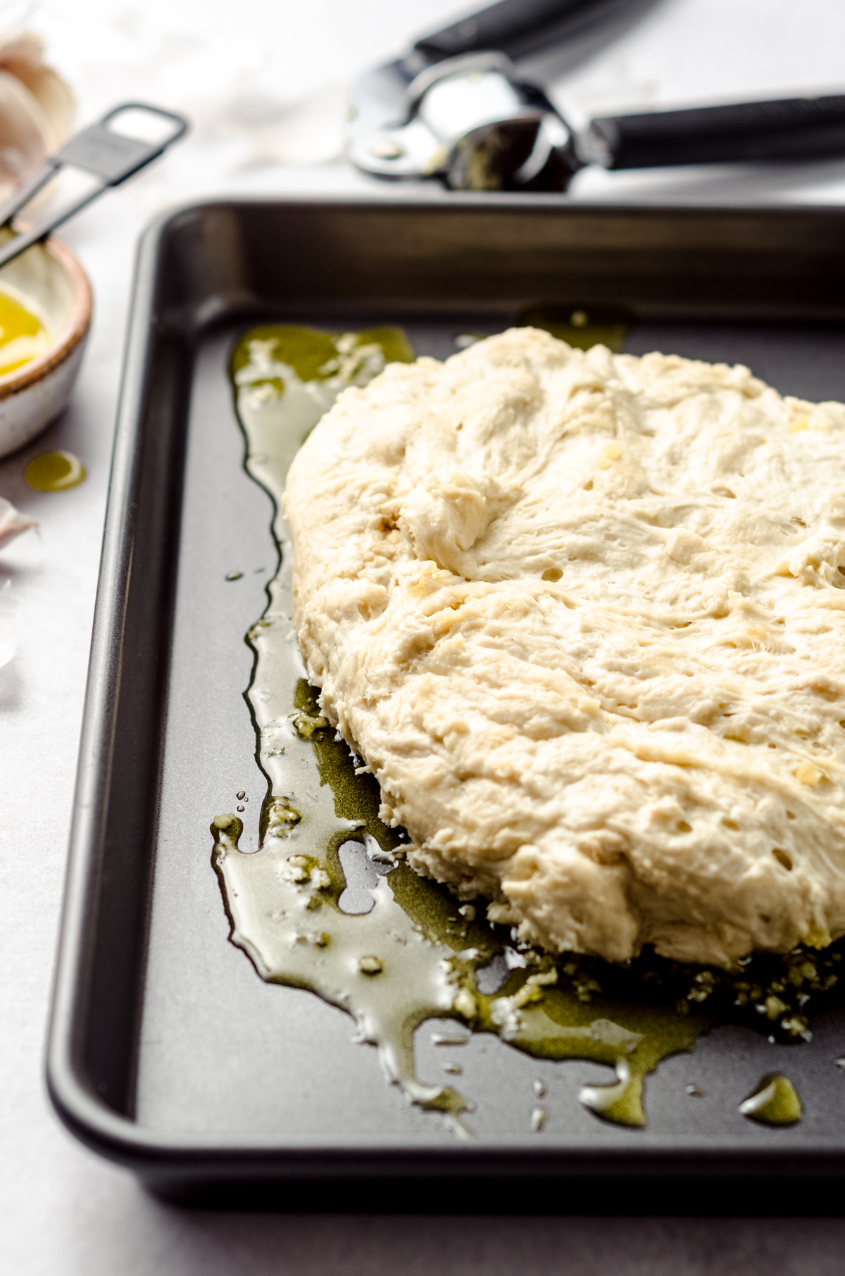 Focaccia dough in a baking dish ready to be dimpled and stretched.