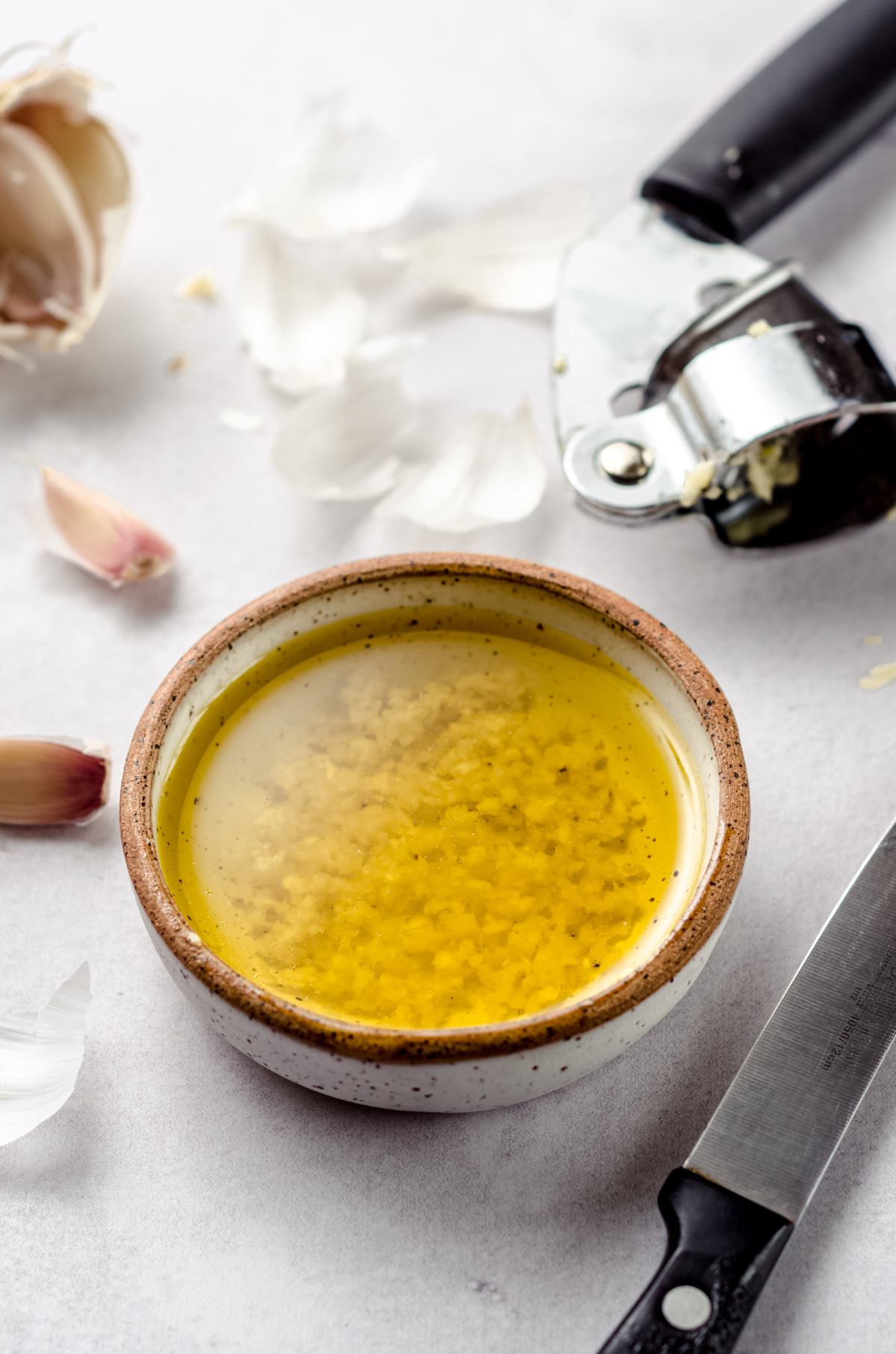 A small bowl of olive oil with minced garlic in it.