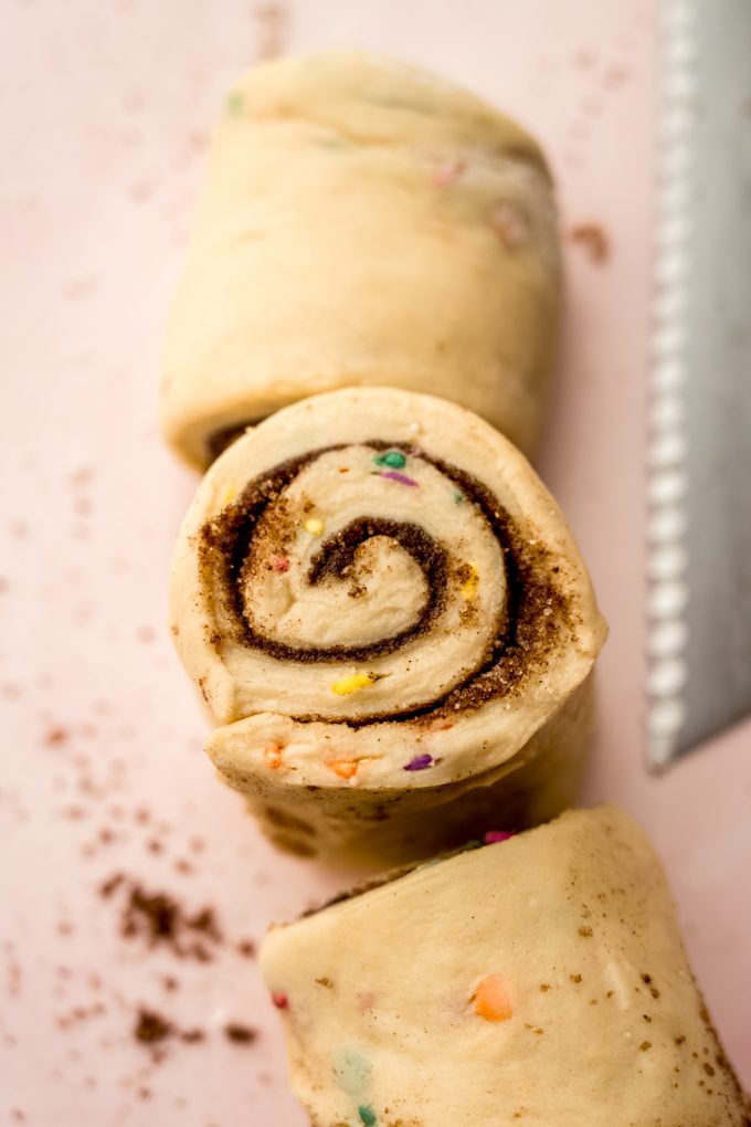A log of funfetti cinnamon rolls that has been cut into slices.