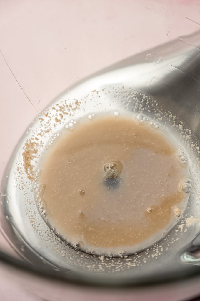 Yeast and water in the bottom of the bowl of a stand mixer.