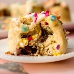 A funfetti cinnamon roll sitting on a plate.