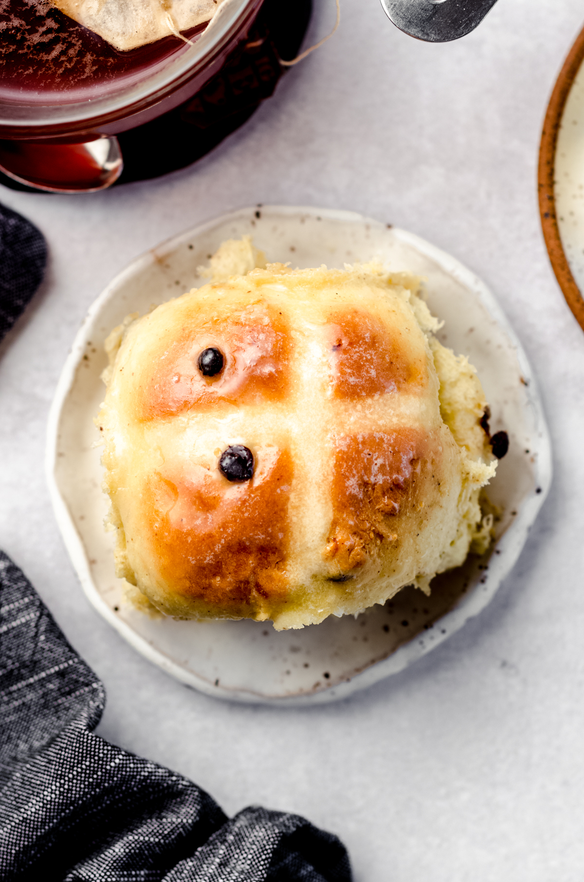 Aerial photo of a hot cross bun on a plate.