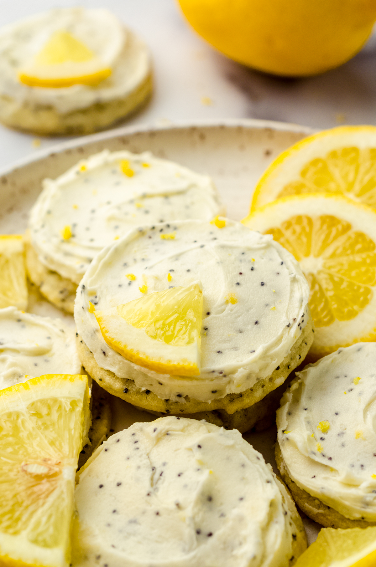 Frosted lemon poppy seed cookies on a plate.