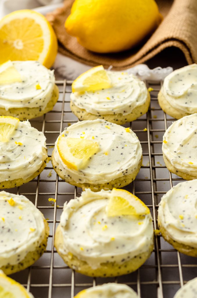Frosted lemon poppy seed cookies on a cooling rack.
