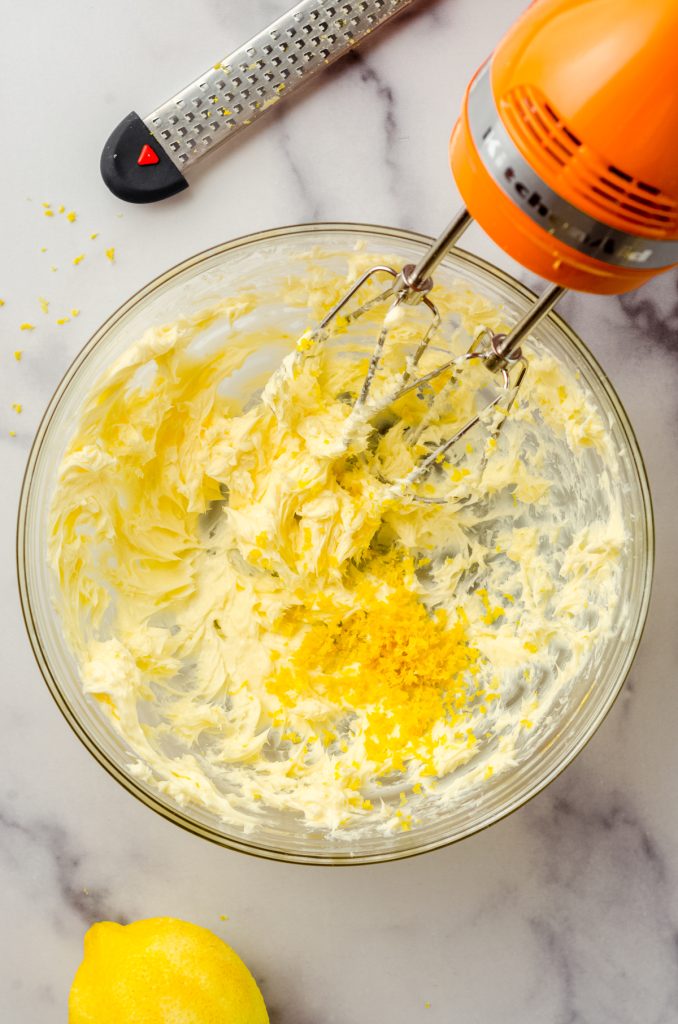 Aerial photo of lemon zest in a bowl of creamed butter to make lemon frosting.