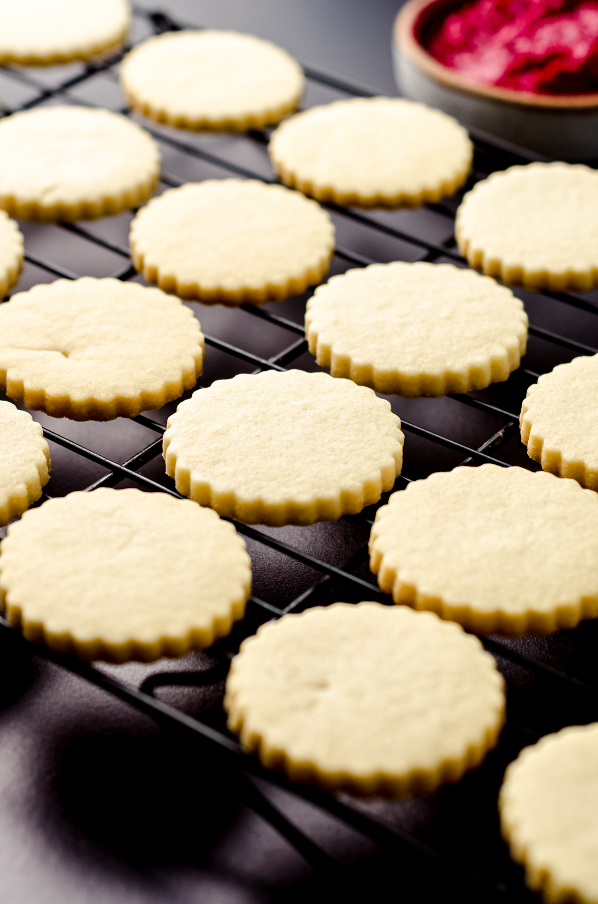 The bottoms of Linzer cookies on a cooling rack.