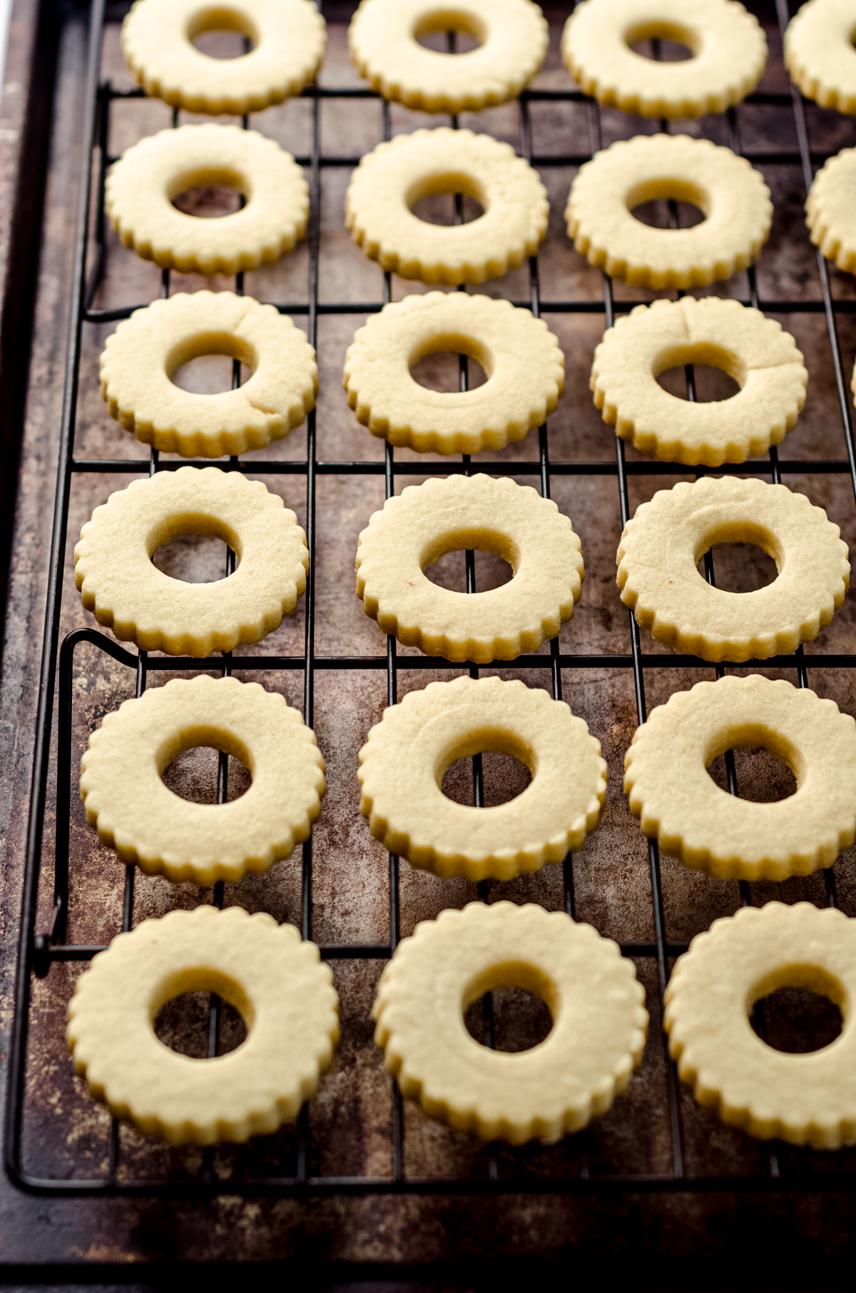 The tops of Linzer cookies on a cooling rack.