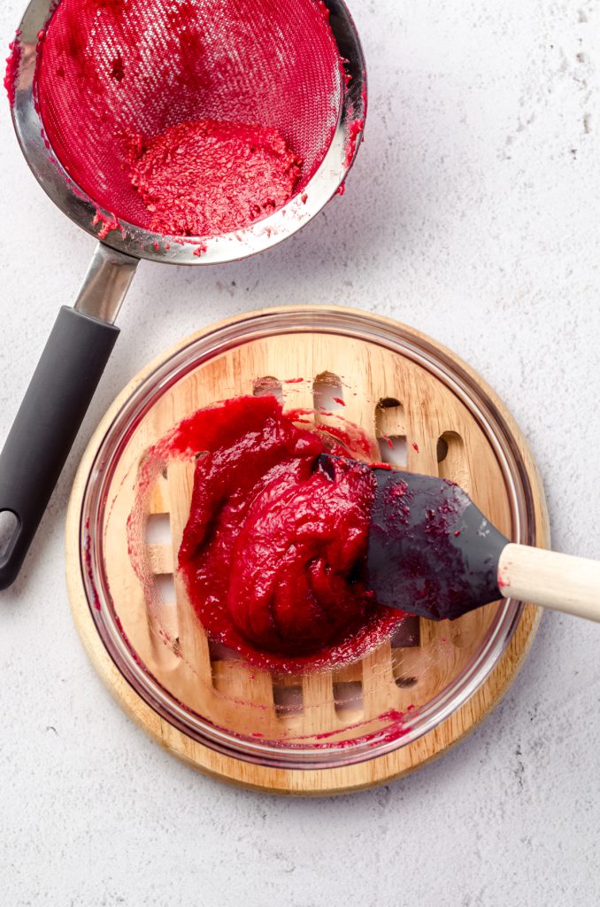 Aerial photo of homemade raspberry spread in a small glass bowl.