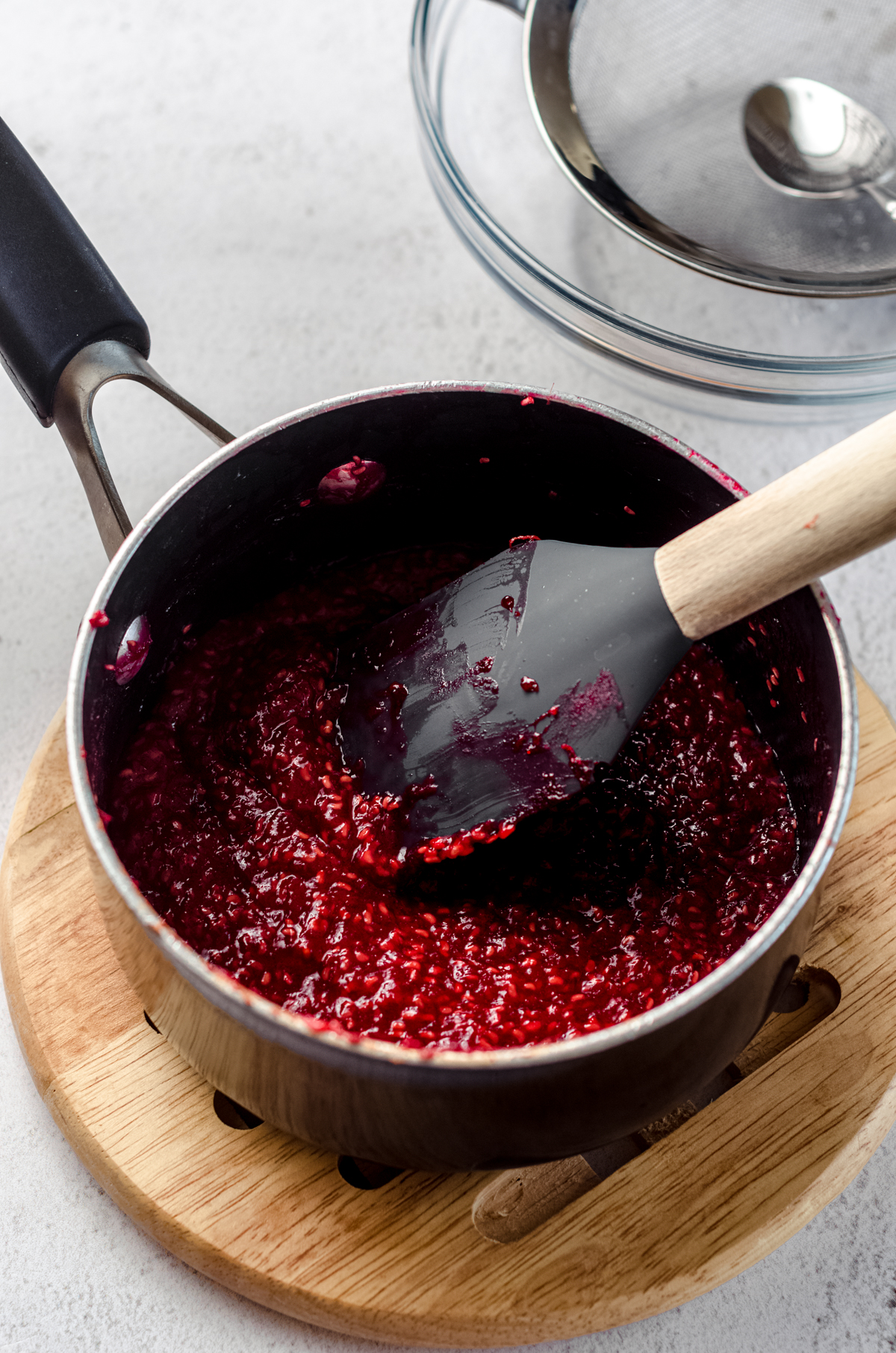 Cooked raspberry spread in a saucepan.