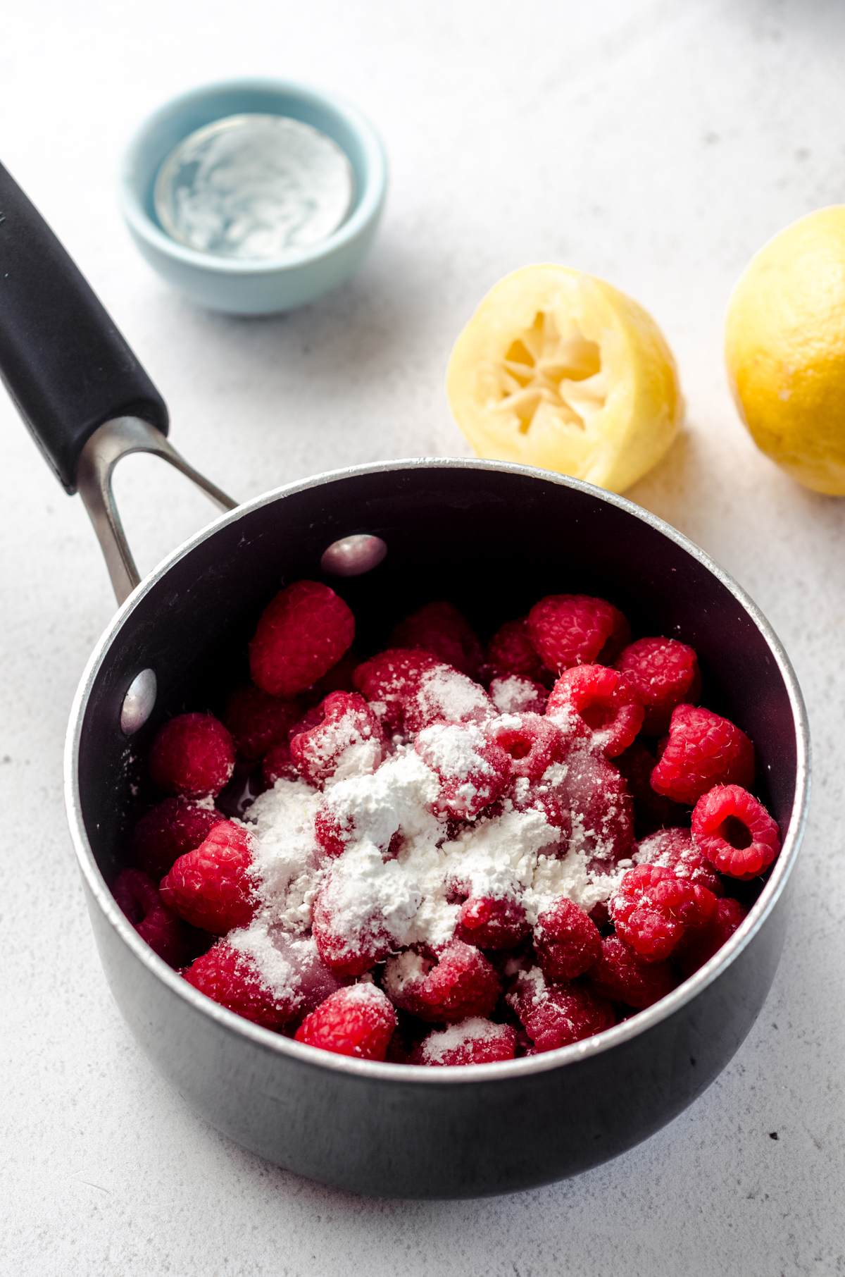 Ingredients for raspberry spread in a small saucepan.