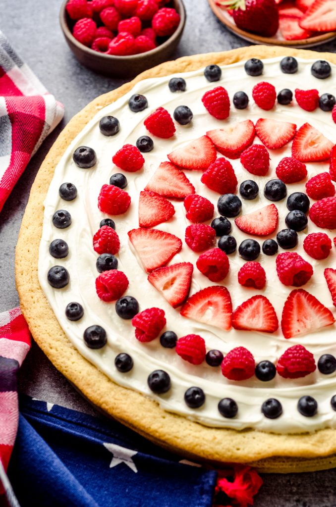 A 4th of July fruit pizza with a sugar cookie crust, fruit dip layer, and fresh fruit in a fun design.