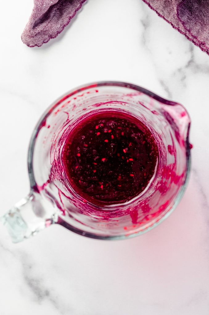 Fresh blackberry puree in a glass measuring cup.