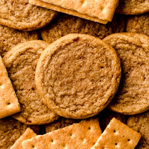 Graham cracker cookies on a surface with graham crackers around it.