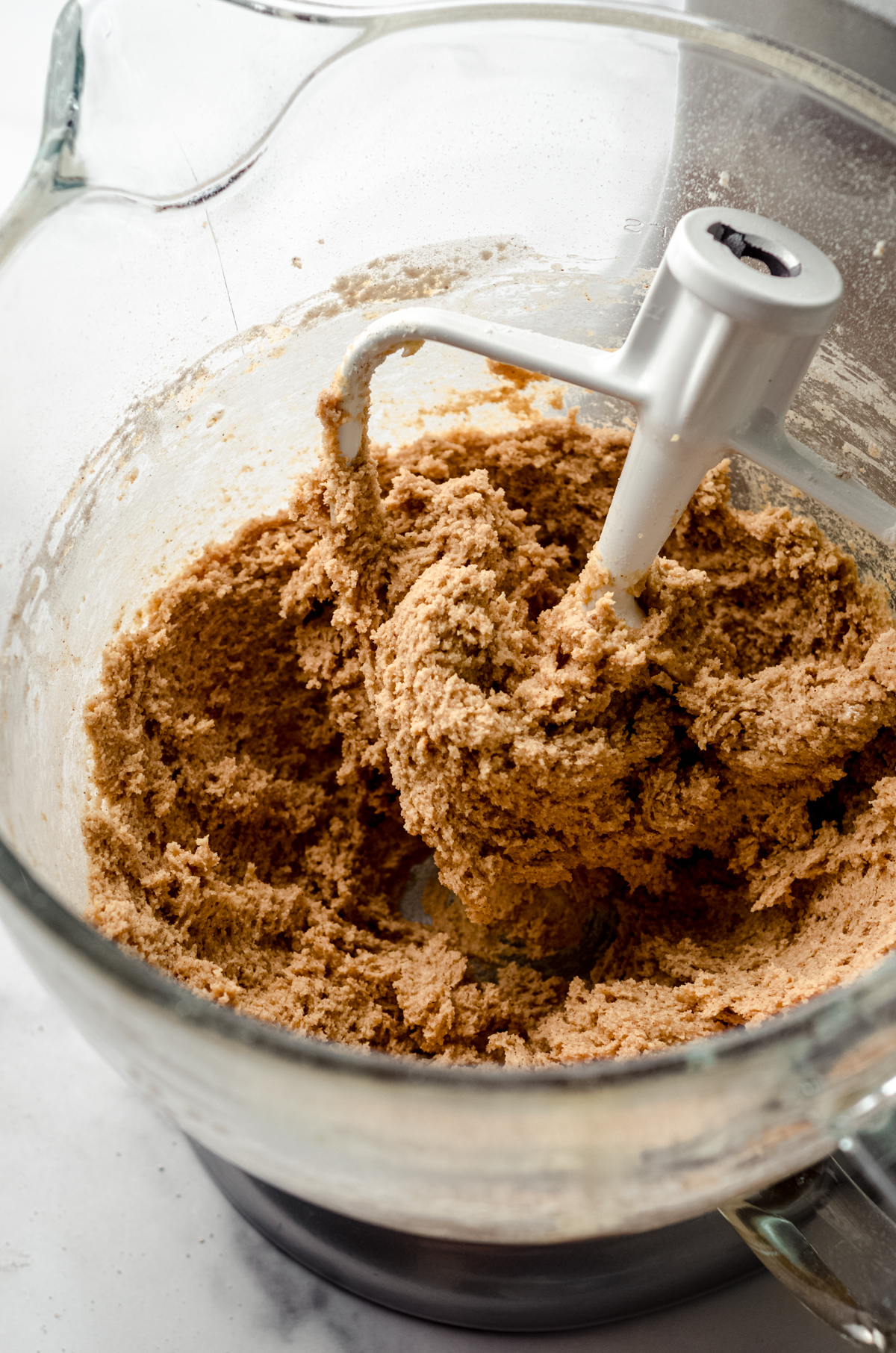 Graham cracker cookie dough in the bowl of a stand mixer.