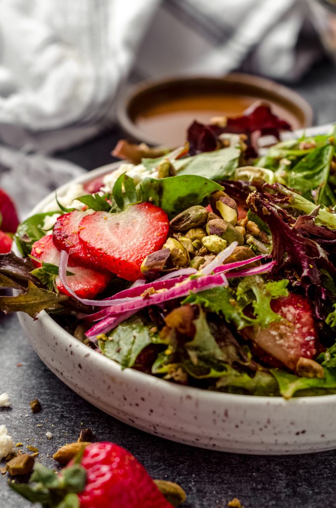 A bowl of strawberry spinach salad.
