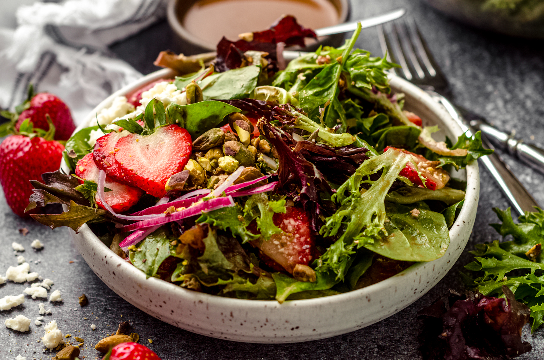 A bowl of strawberry spinach salad.