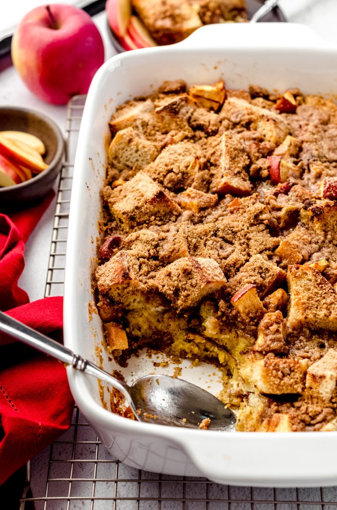 Baked apple French toast casserole in a dish on a cooling rack.