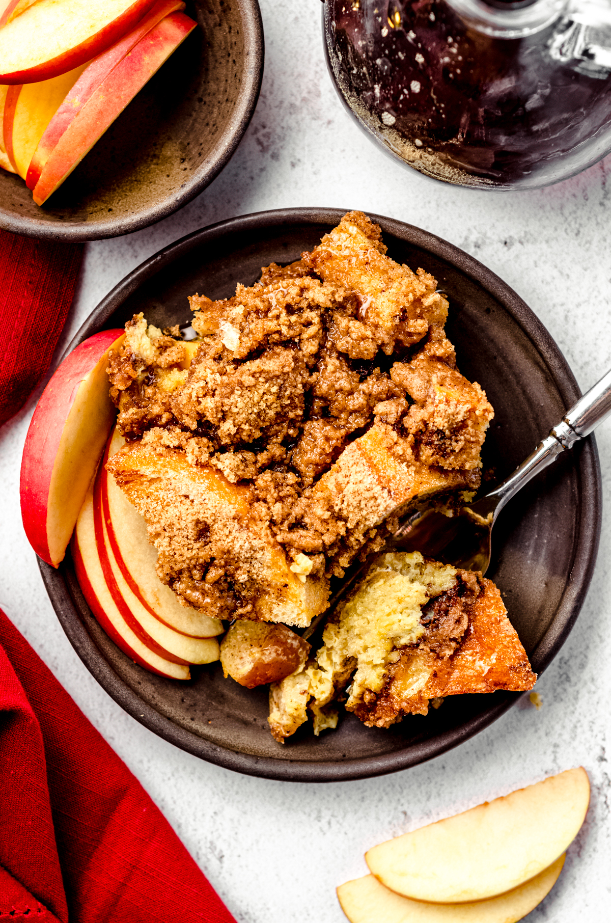 Aerial photo of a serving of apple French toast casserole on a dish with a fork.