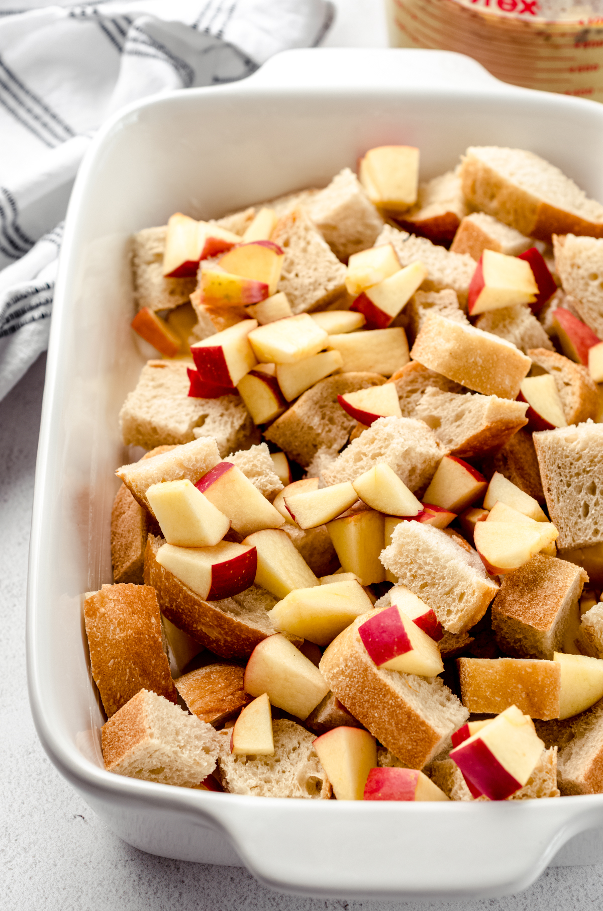 Apples and bread cubes in a casserole dish to make apple French toast casserole.