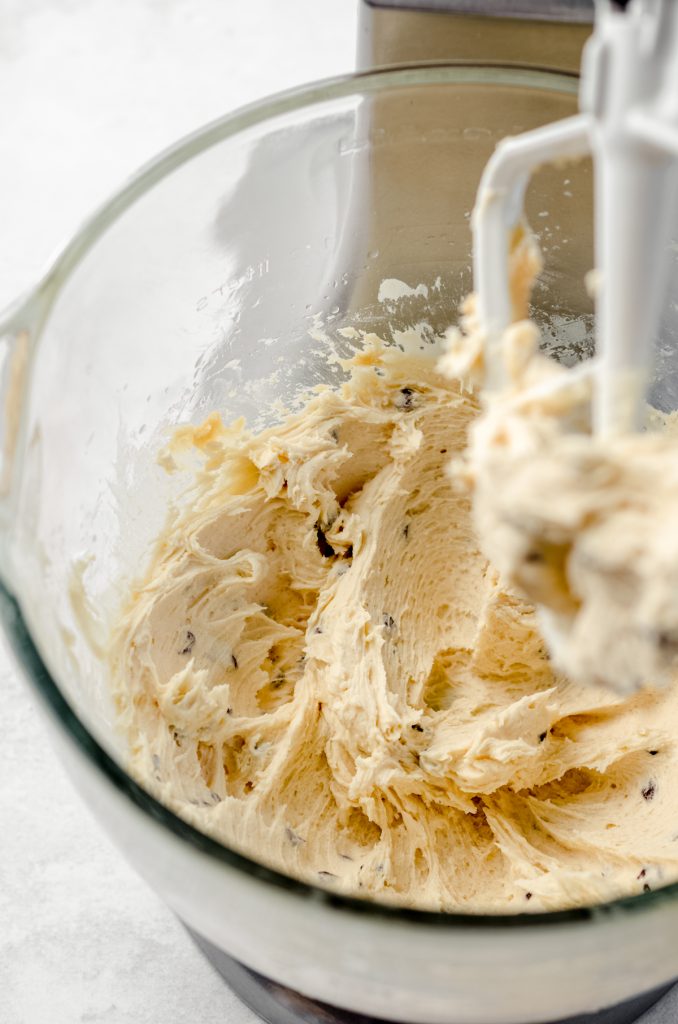 Cookie dough frosting in the bowl of a stand mixer.