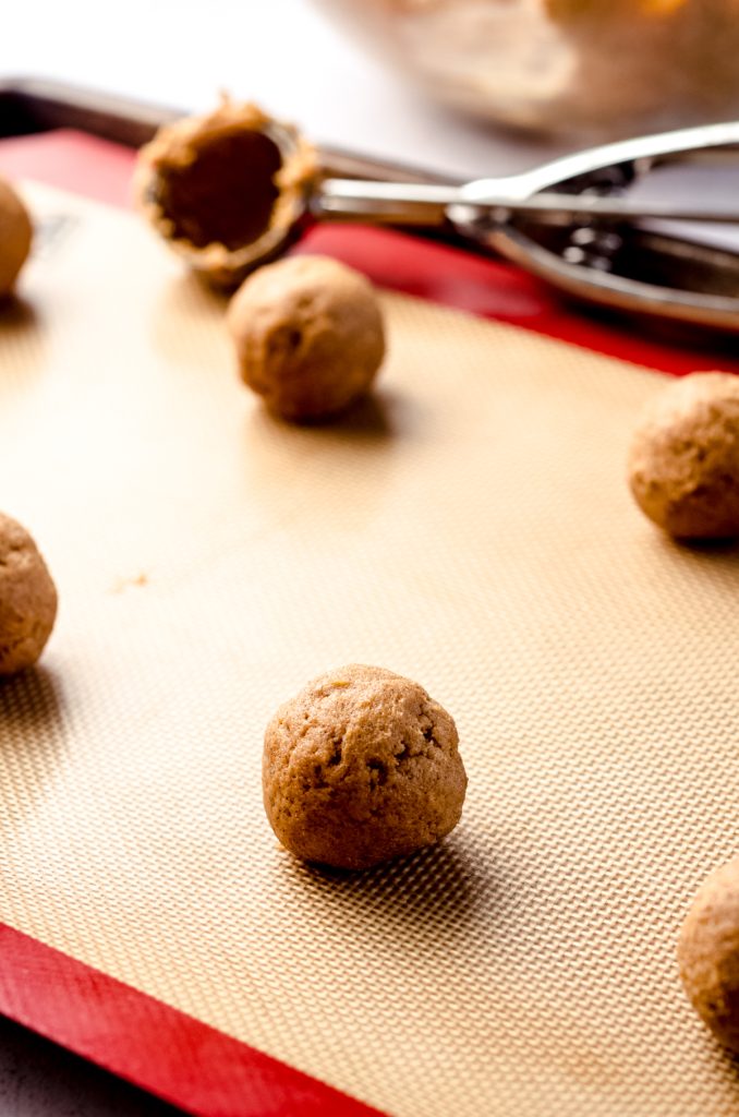 Pumpkin cookie dough balls on a baking sheet.