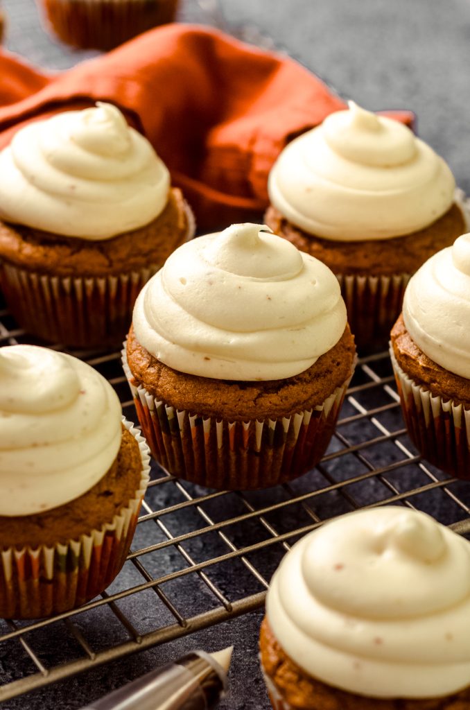 Pumpkin cupcakes sitting on a cooling rack.