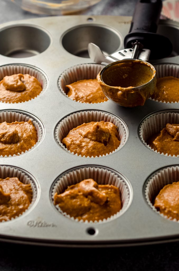 Pumpkin cupcake batter in a muffin pan.
