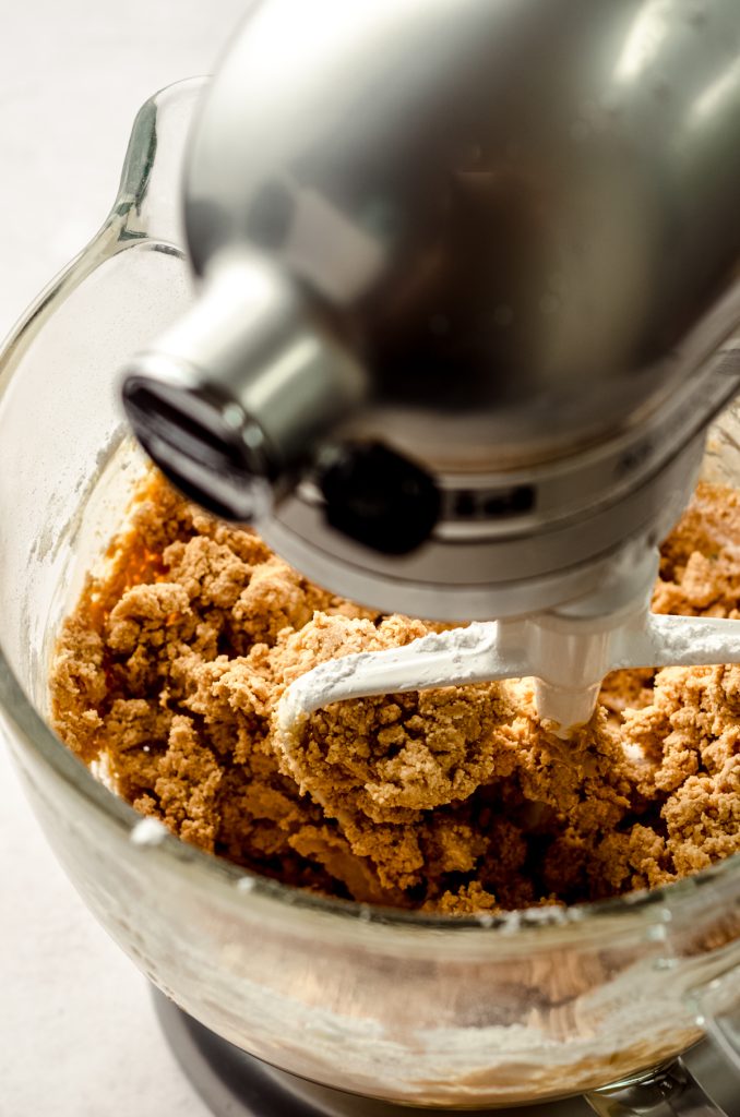 Peanut butter frosting coming together in a stand mixer.