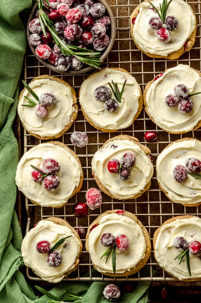 Frosted cranberry cookies on a wire cooling rack.