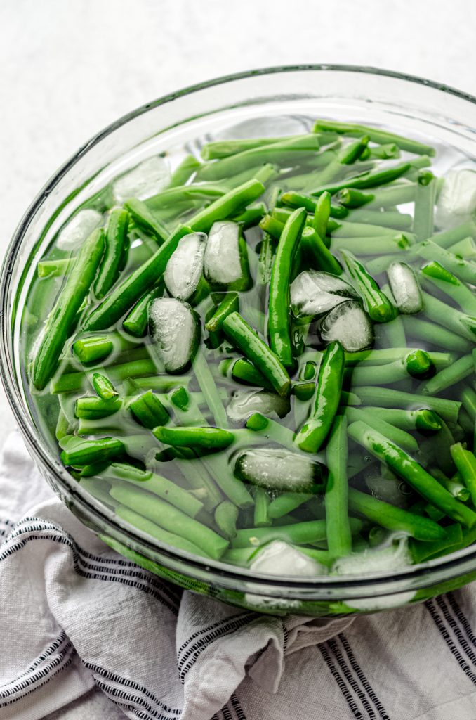 Blanched green beans in a large ice bath to stop the cooking.
