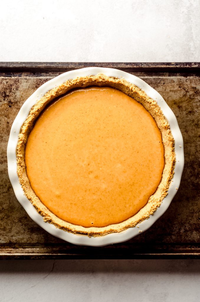 Pumpkin pie with graham cracker crust ready to go in the oven.
