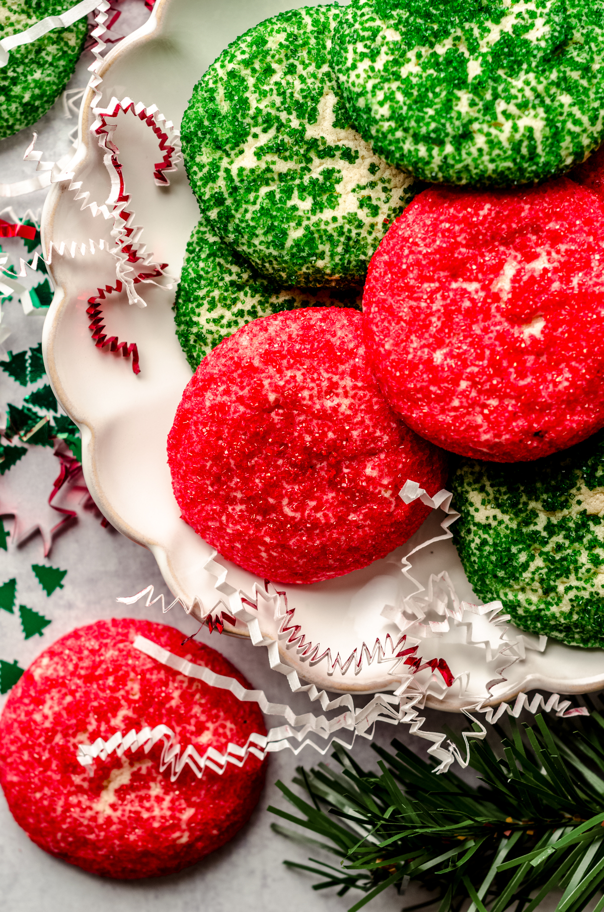 Red and green drop Christmas sugar cookies on a plate.