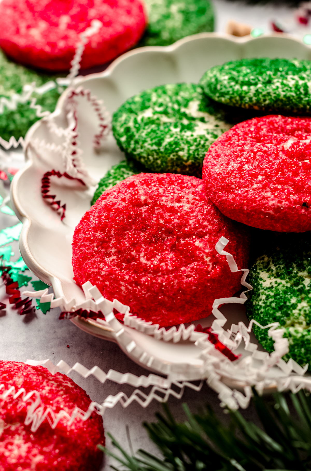 Red and green drop Christmas sugar cookies on a plate.
