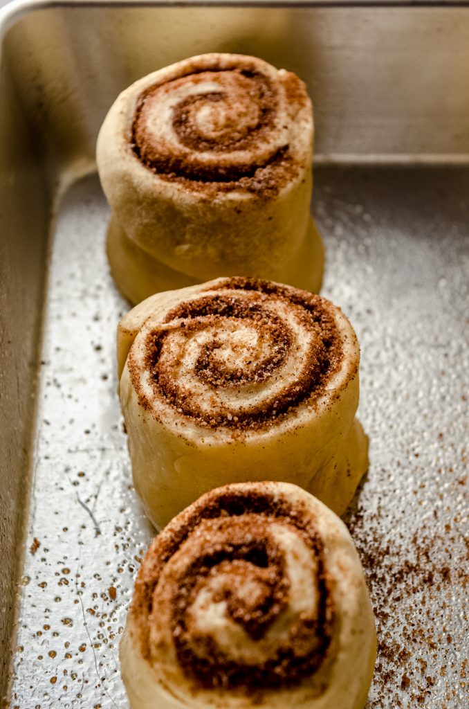 Eggnog cinnamon rolls in a baking dish before rising.