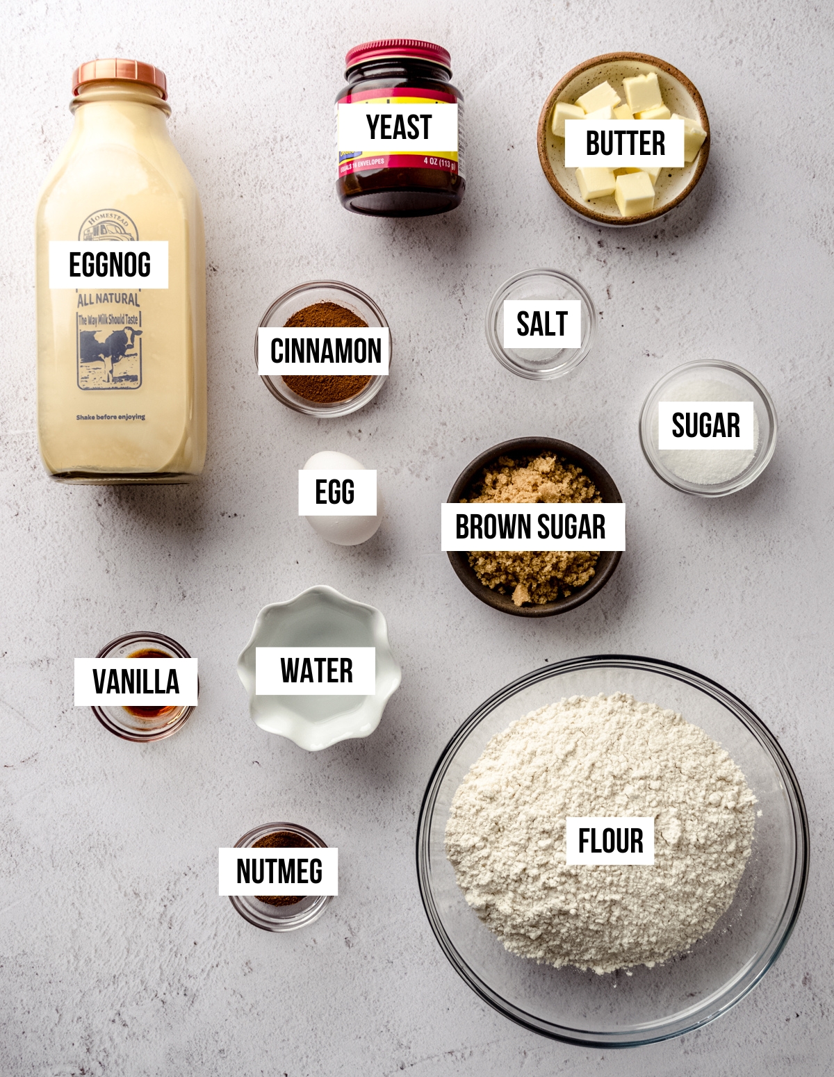 Aerial photo of ingredients for eggnog cinnamon rolls with text overlay.