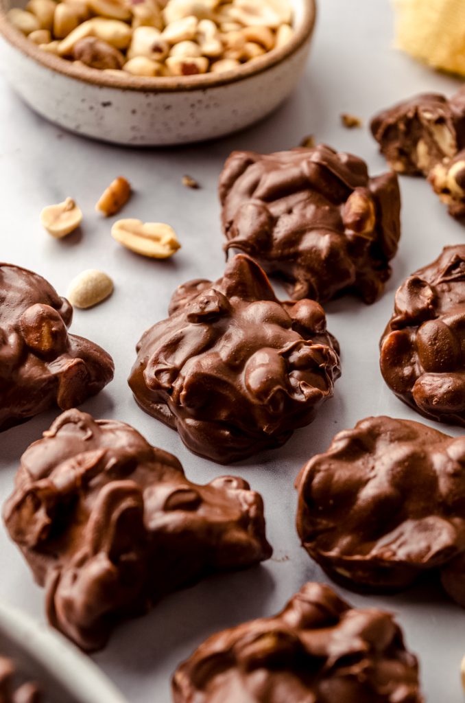 Slow cooker peanut clusters on a surface.