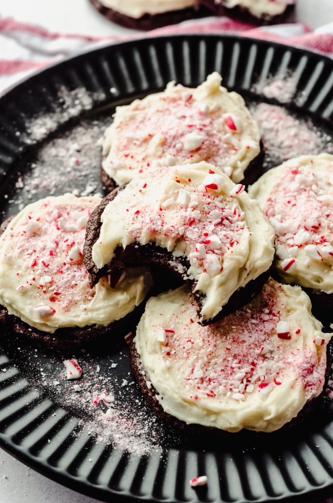 Aerial photo of peppermint bark cookies on a plate. The one on the top has a bite taken out of it.