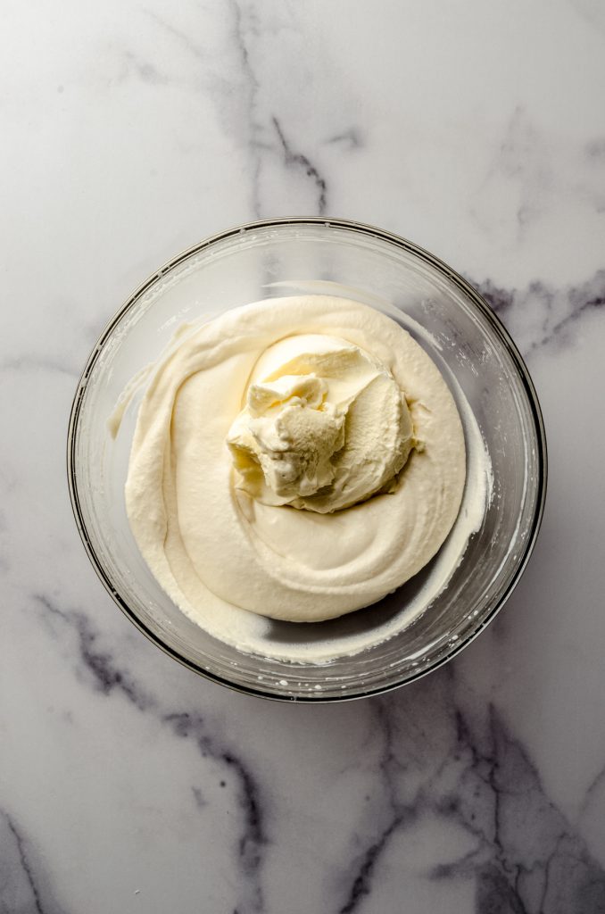 Aerial photo of mascarpone cheese in a bowl of whipped cream.