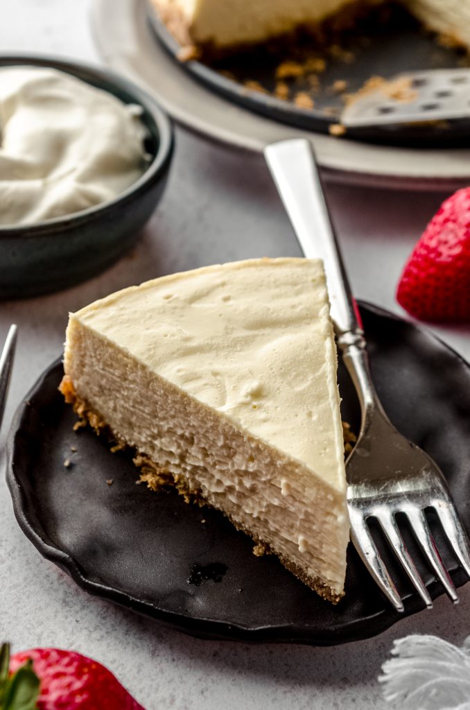 A slice of Instant Pot cheesecake on a plate with a fork.