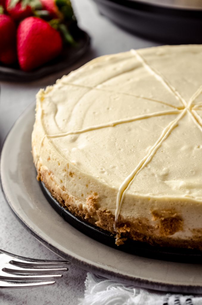 An Instant Pot cheesecake on a plate. It has been sliced.