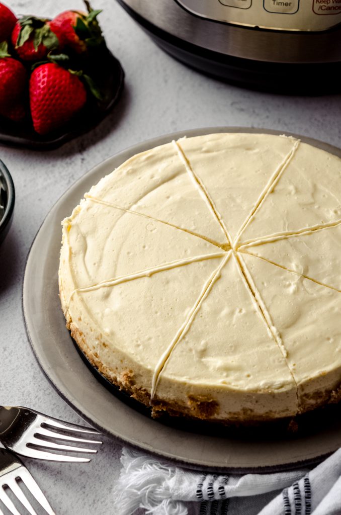 An Instant Pot cheesecake on a plate. It has been sliced.