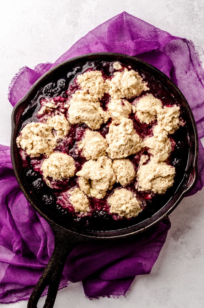 Aerial photo of blackberry dumplings in a cast iron skillet ready to cook.