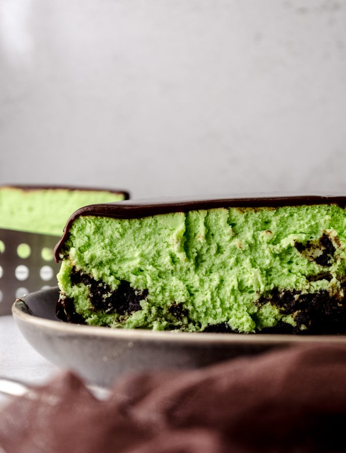 The cross-section of a mint chocolate cheesecake on a plate.