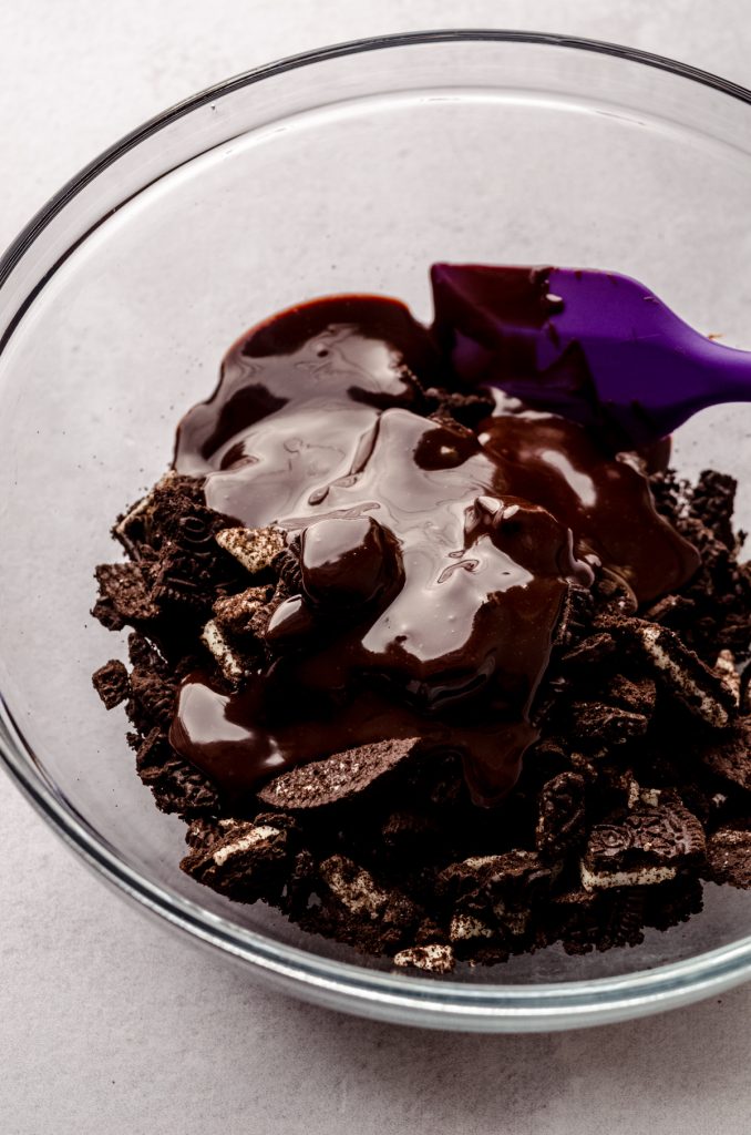 Chopped Oreos covered with hot fudge to make filling for a mint chocolate cheesecake.
