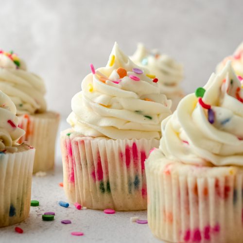 Funfetti cupcakes sitting on a surface.